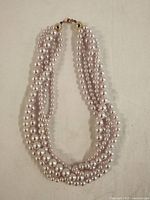 Full view of the 17-inch multi-strand pearl necklace showing twisted design and gold-tone clasp.