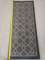 Full view of the rectangular rug with a tape measure showing its length at about 47 inches.