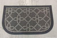 Full view of the rectangular grey rug showing geometric pattern and dark outer border.