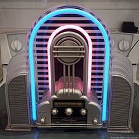 Front view of vintage Marilyn radio showing pink and blue neon lights, silver front with dials and tuning display.
