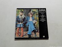 Front cover of ABBA Greatest Hits vinyl LP album featuring two female band members on a bench
