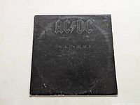 Front cover of AC/DC Back in Black vinyl album showing black matte cover with AC/DC text and title.