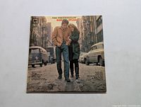 Front cover of The Freewheelin Bob Dylan LP showing Bob Dylan and woman walking on street with old cars, visible wear on corners and surface.
