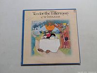 Front cover of Cat Stevens Tea for the Tillerman LP showing artwork of a person at a tea table with a large orange fruit overhead.