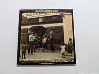 Front cover photo of Creedence Clearwater Revival LP Willie and the Poor Boys showing band members and vintage market storefront with noticeable wear on edges.