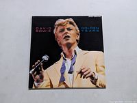 Front cover of David Bowie Golden Years LP showing photo of Bowie in suit holding microphone.