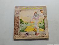 Front view of Elton John Goodbye Yellow Brick Road 2 LP album cover showing illustrated design with signs of wear
