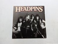 Front cover of the Headpins 'Line of Fire' LP showing the band members in black and white photo with the band name and album title.