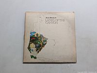 Front cover of the 'Ladies of the Canyon' LP by Joni Mitchell shows stylized line drawing of a woman with colorful detail on the skirt area.