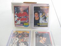 Four hockey cards in plastic sleeves showing key players Mario Lemieux, Jaromir Jagr, Wayne Gretzky, Guy Lafleur