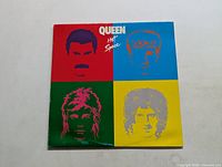 Front cover of Queen's Hot Space vinyl album featuring colorful stylized portraits of band members.