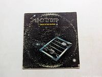 Front cover of Supertramp Crime of the Century album showing space-themed artwork with barred window and hands.