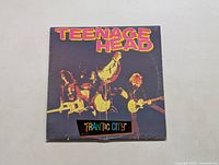 Front album cover of Teenage Head LP titled Frantic City showing the band performing with instruments in a black background with colorful title text.
