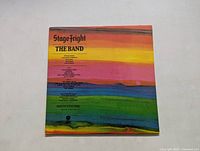 Back cover of album showing tracklist and credits with colorful striped background