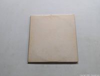 Front cover of the first LP in the white plain cover showing faint embossed The Beatles text.