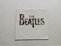 Front cover of The Beatles '20 Greatest Hits' album sleeve showing the album and band name with collage style lettering.