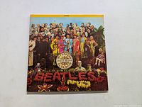 Front album cover of Sgt. Pepper's Lonely Hearts Club Band by The Beatles showing the colorful group photo and typography.