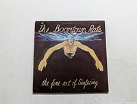 Front cover of The Boomtown Rats LP titled The Fine Art of Surfacing showing a swimmer underwater with extended arms.