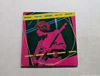 Front cover of The Kinks LP showing guitarist in pink and green with yellow text