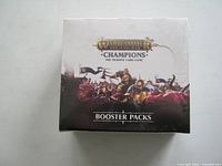 Front view of the sealed box showing Warhammer Age of Sigmar Champions branding and artwork of warriors and creatures.