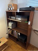 Front view of the wooden bookcase with items on shelves (not included in sale)