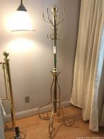 Full view of the brass metal coat stand showing height, base, and overall structure.
