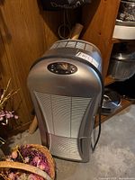 Front view of the silver Danby dehumidifier showing the vented front panel and top control area taken in basement setting.
