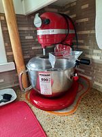 Front-left view of red KitchenAid Professional 600 stand mixer with stainless steel bowl and pouring shield installed
