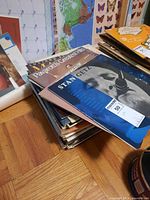 Stack of vinyl LP records showing top titles 'Stan Getz' and 'Pavarotti's Greatest Hits' with visible album covers.