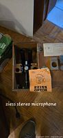 Zeiss stereo microscope in its wooden box with original instruction manual and foam padding inside the box.