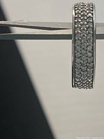 Side view of the .925 silver wedding band showing the embedded rows of clear Swarovski crystals under bright lighting.