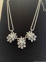 Front view showing the entire necklace on black background to highlight crystal clusters and chain design