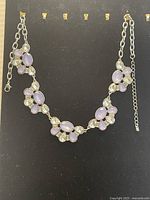 Full view of the necklace showing the alternating moonstone and clear stones in clusters on a silver-tone chain.