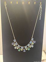 Full view of the colorful stone necklace on display card showing the entire chain and stone arrangement.