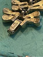 Close-up of the clasp showing signature brand stamp and other markings.