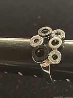 Close-up top view of the silver plated artsy ring showing circular elements with rhinestone accents on a ring mandrel.