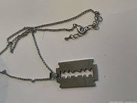 Photo showing the stainless steel razor blade pendant on chain with clasp and adjustable links