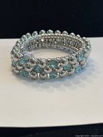 Shows the bracelet on a white background highlighting the silver-tone metal beads and light blue crystals.