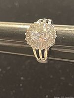 Close-up photo of silver-tone ring with prominent large round Swarovski crystal and smaller surrounding crystals.