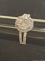 Close-up photo of Swarovski crystal solitaire ring showing large central crystal surrounded by smaller crystals and split band.
