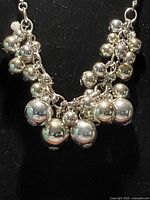 Close-up front view of the silver-tone necklace showing the cluster of spherical beads.