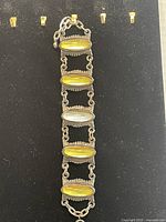 Full view of the vintage bohemian bracelet showing all six linked oval cabochon yellow stones on silver-tone metal.