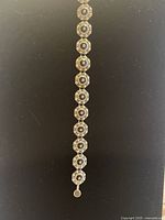 Bracelet laid flat showing linked circular elements and magnetic clasp end.