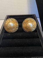 Front view of both earrings showing sunburst design, faux pearl and rhinestones