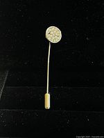 Front view of vintage gold plated stick pin brooch showing round head with clear crystal clusters.