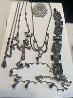 Overview of all jewelry pieces including necklaces, bracelet, and brooch on white background