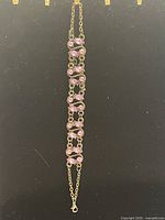 Full view of the bracelet showing the linked chain with pink Swarovski crystals and lobster clasp closure.