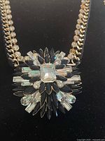 Close-up front view of the large statement pendant featuring marquise black stones and clear rectangular and teardrop rhinestones on a gold-tone chain with clear rhinestone links.