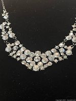 Close-up of the front of the vintage rhinestone necklace showing clustered clear crystals and detailed design.