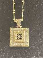 Front view of square Swarovski crystal charm pendant with gold-tone chain.